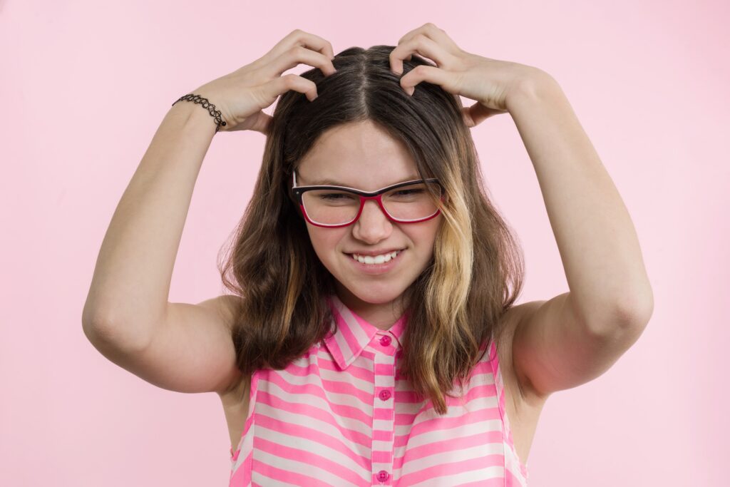 teen-girl-with-glasses-with-long-hair-scratches-head-because-of-head-lice